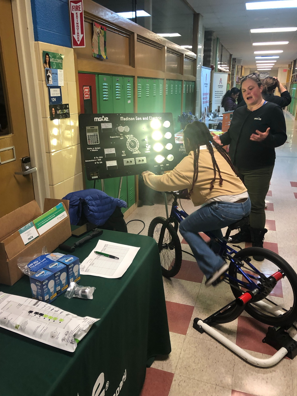 Leah Samson, a Residential Energy Engineer at MGE, uses the Pedal Power bike to explain how energy can generate electricity as a student quickly pedals the Pedal Power bike.   
