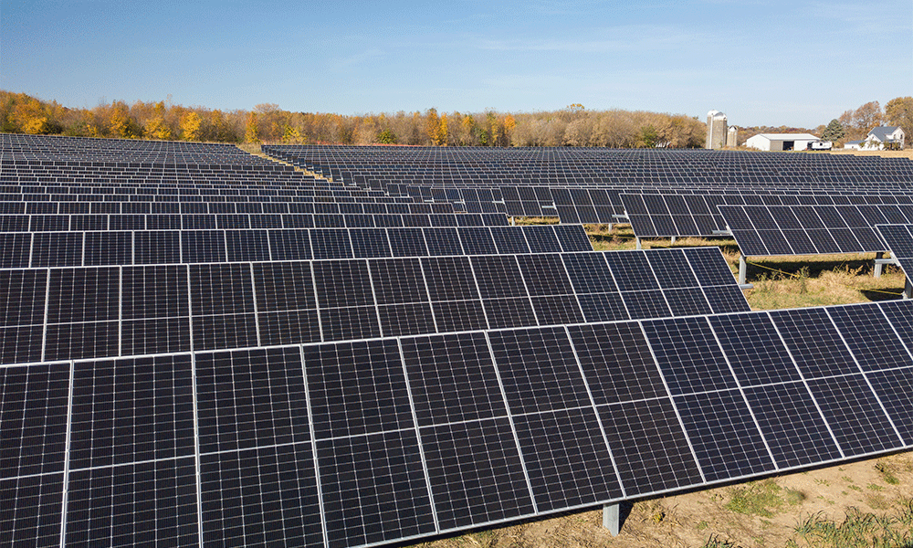 Una vista de dron de Strix Solar en Fitchburg con árboles otoñales y una granja al fondo.