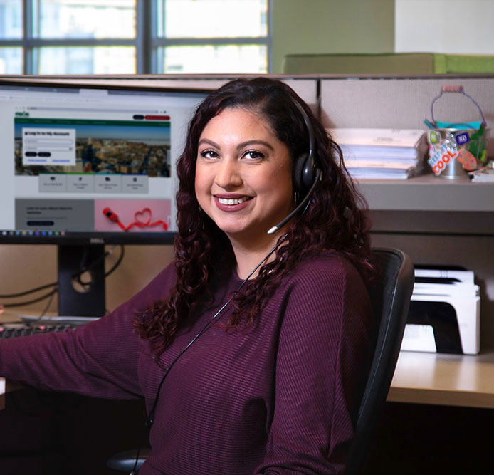 An MGE call center representative at her desk and ready to help answer questions.