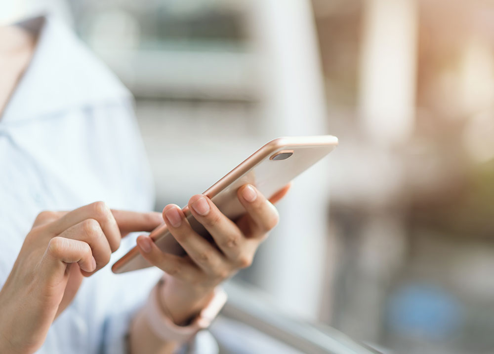 Closeup of person dialing on a mobile phone to report a natural gas leak.