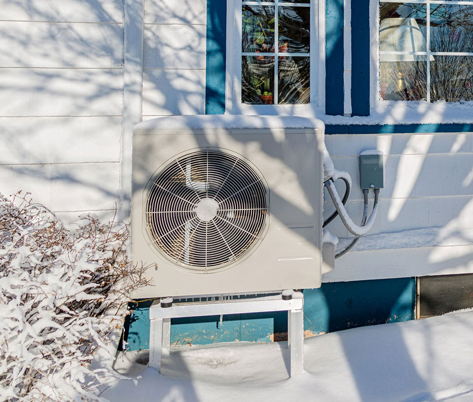 Heat pump outside a home in winter