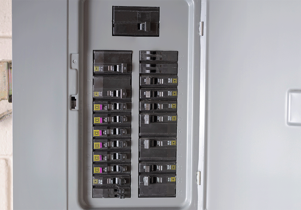 Un vistazo de cerca de un panel eléctrico gris con interruptores negros.