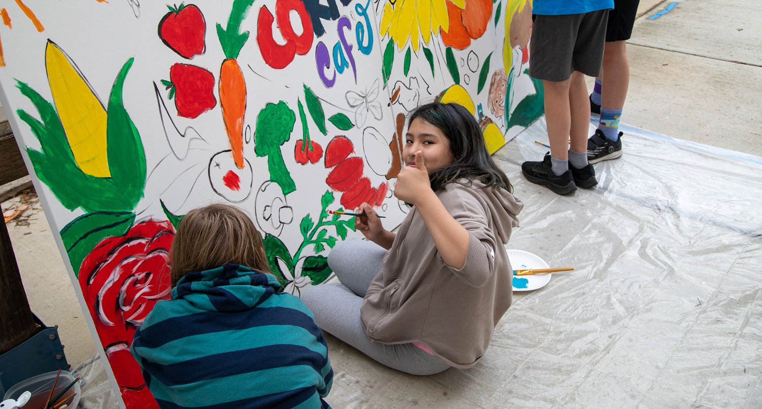 Students painting a mural with MGE