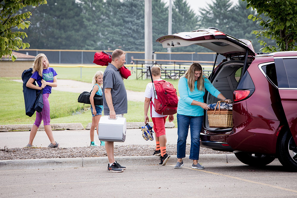 Family packing up minivan after a baseball game