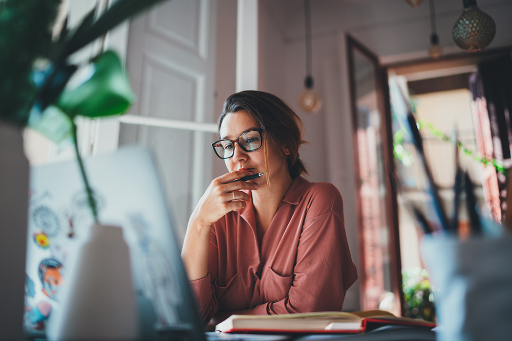 Woman thinking while working on computer.