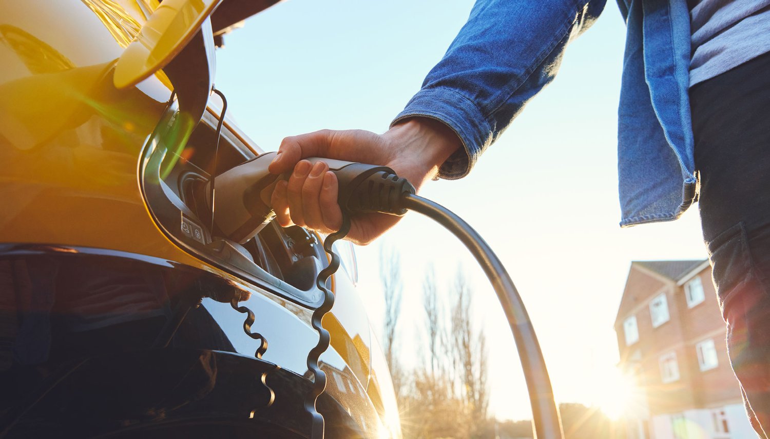 Person charging an electric vehicle.