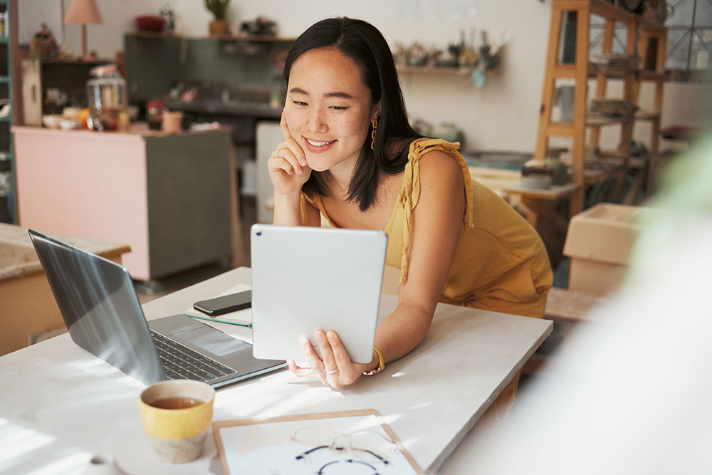 Woman reading on a  tablet at her small business.