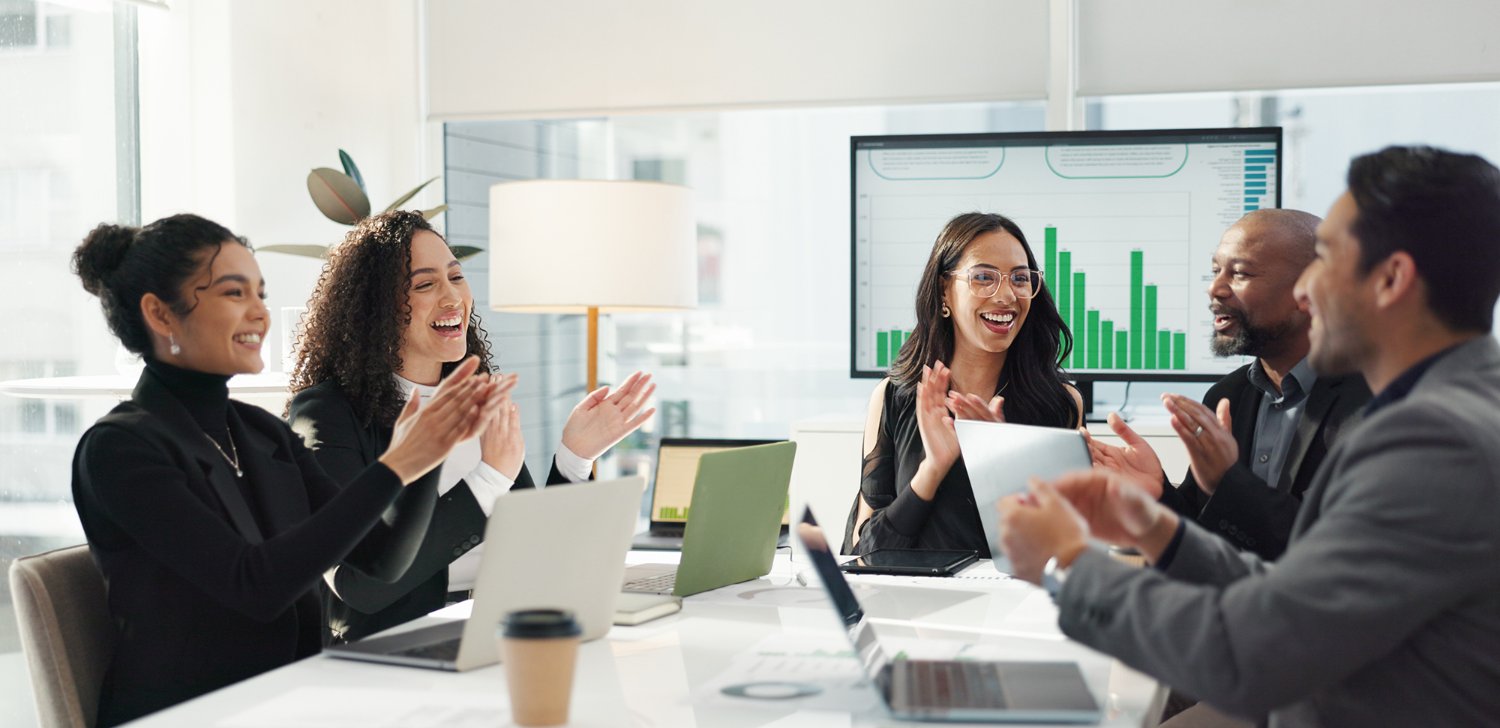 Coworkers clapping in a meeting.
