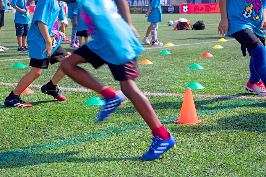 Kids running across a soccer field