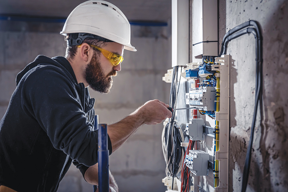 Electrician installing a surge protector in an electrical switchboard. 