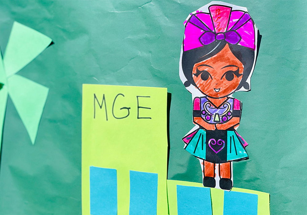 A closeup of a female character that's been colored, cut out and attached to a green story cloth.