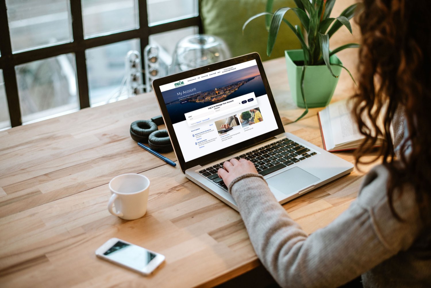 woman at a desktop using a laptop. the new My Account homepage is displayed on the screen.